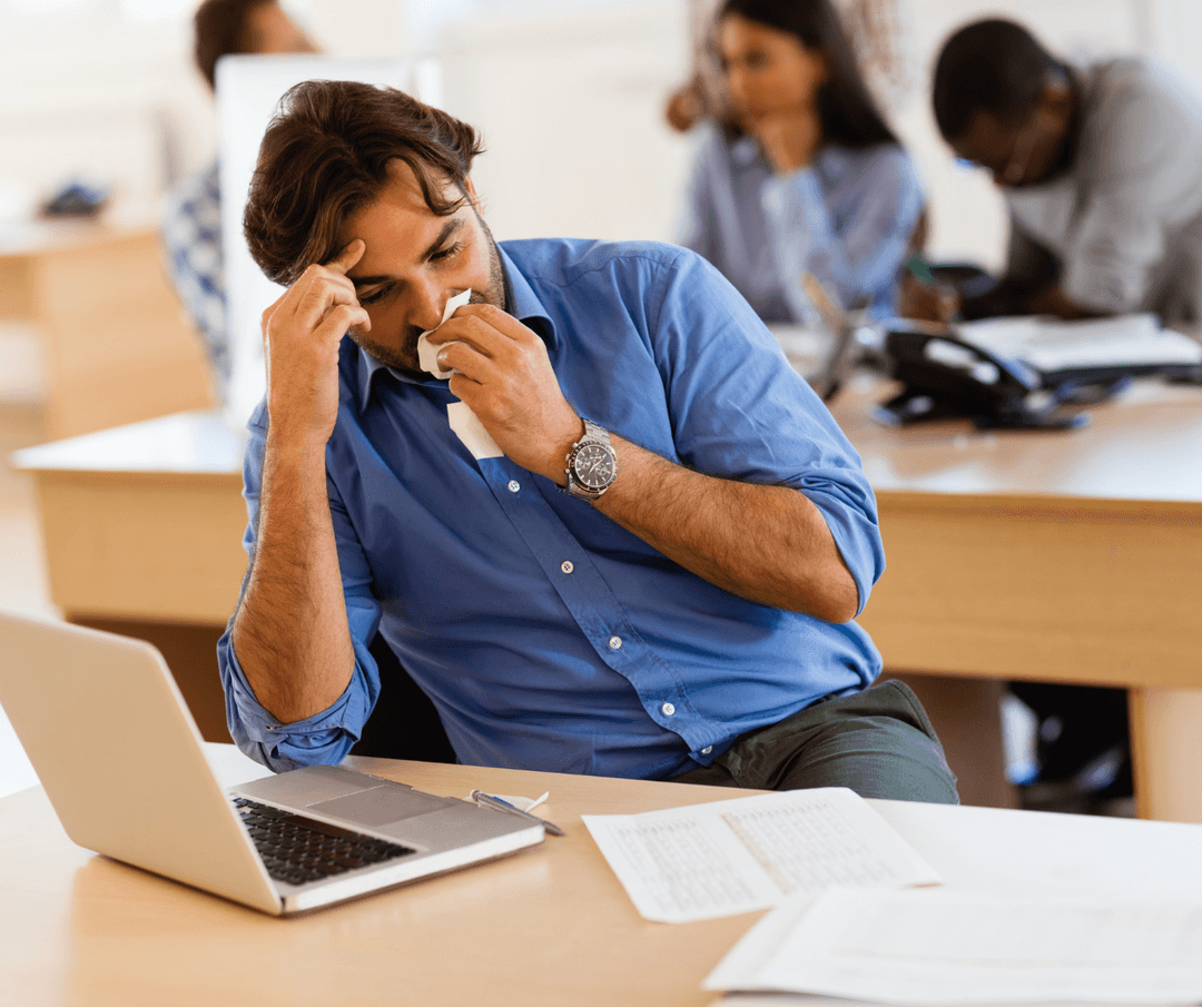 Sick patient coughing while resting in couch with a blanket.