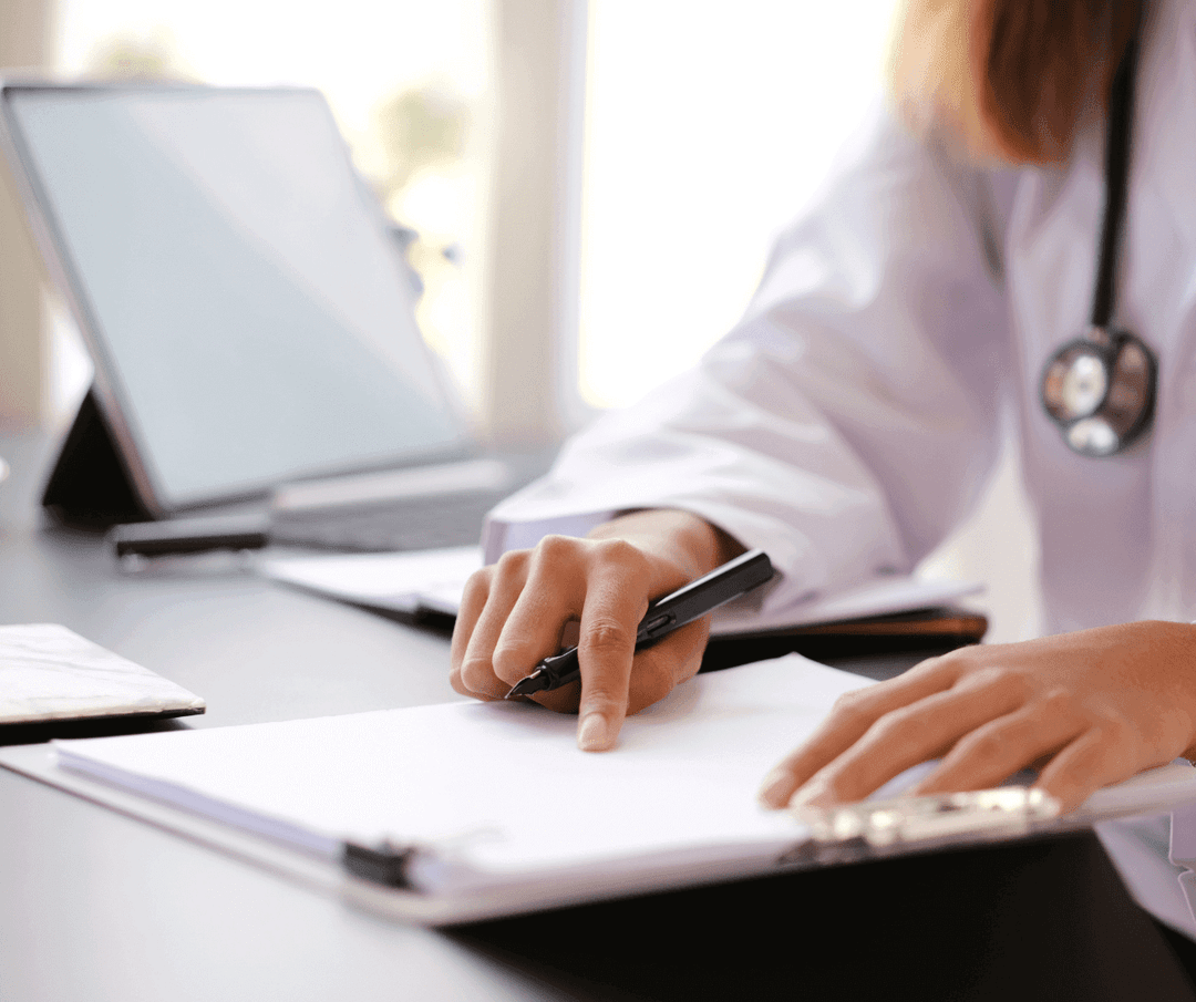 Doctor reading referral letter while holding a pen.